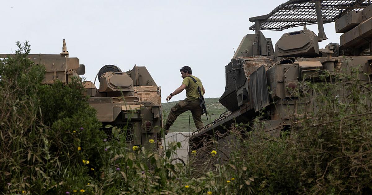 Un soldado israelí salta entre vehículos blindados cerca de la frontera con Líbano, el 17 de abril de 2026, en el norte de su país.