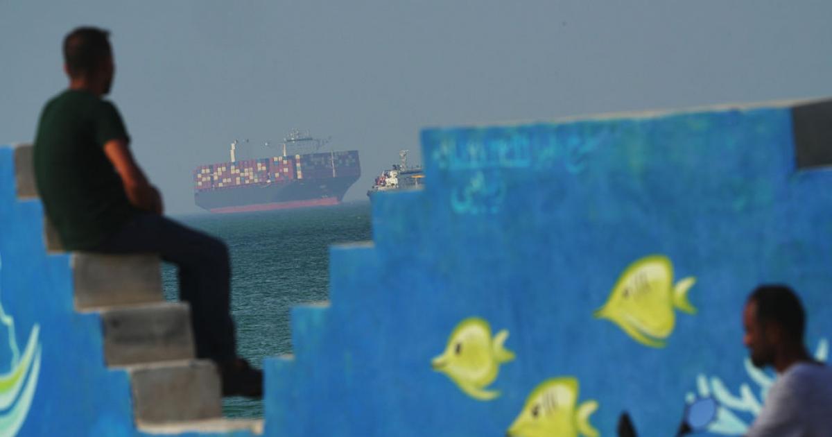 Un carguero navega tras un mural que representa peces en la costa de la isla de Qeshm, Irán, en el estrecho de Ormuz, el 28 de abril de 2026.
