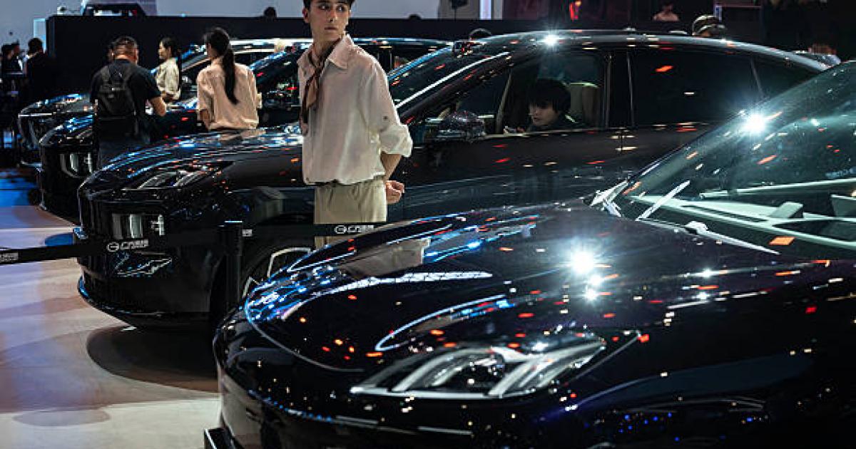 BEIJING, CHINA - APRIL 24: A host stands next to a new electric car from Chinese automaker Hyptec as it is displayed on media day at the Beijing International Auto Exhibition on April 24, 2026 in Beijing, China.The biennial showcase, held at the China International Exhibition Center, brings together leading global and domestic automakers to unveil their latest models, concept vehicles, and electric mobility innovations for the world's largest automotive market. (Photo by Kevin Frayer/Getty Images)