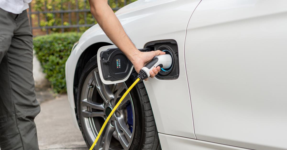 Una persona cargando un coche eléctrico, en una imagen de archivo