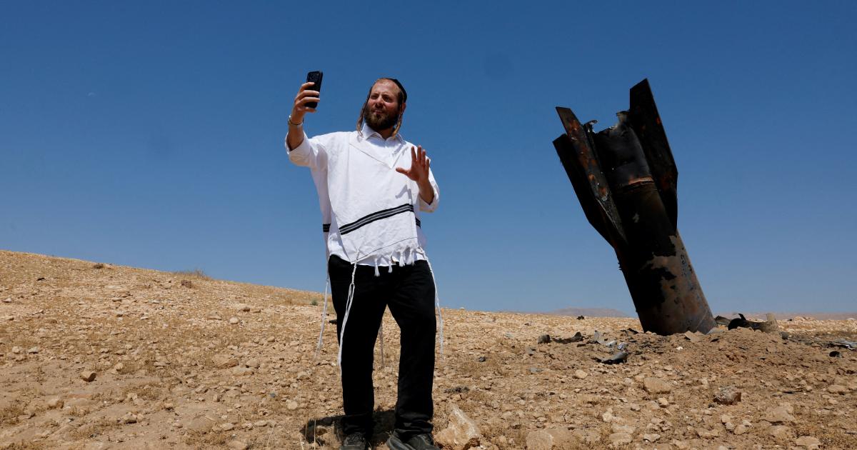 Un israelí ultraortodoxo posa ante los restos de un misil iraní, en el West Bank, en la Cisjordania ocupada por Israel.
