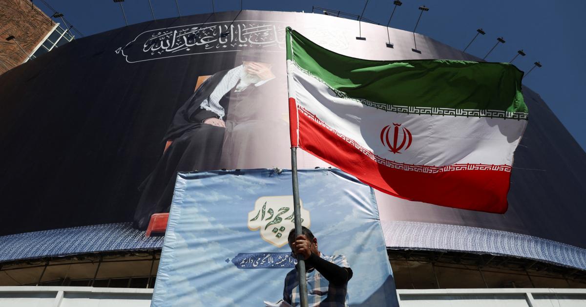 Un hombre sostiene una bandera iraní en una calle de Teherán (Irán), 15 de junio de 2026, tras el anuncio de acuerdo con EEUU.
