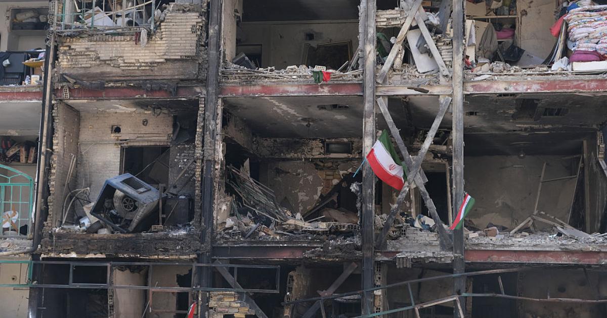 Banderas iraníes ondean en un edificio de un complejo residencial en el sureste de Teherán, gravemente dañado por un ataque de Israel y EEUU, el 5 de marzo de 2026.