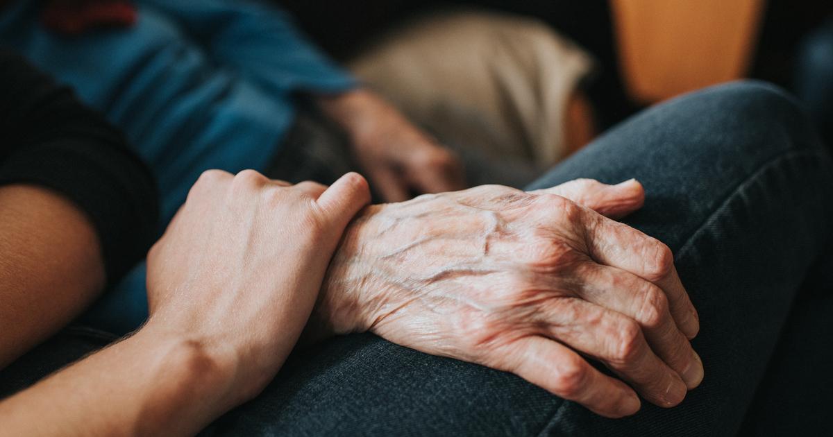 Una persona joven sosteniendo la mano de una persona mayor