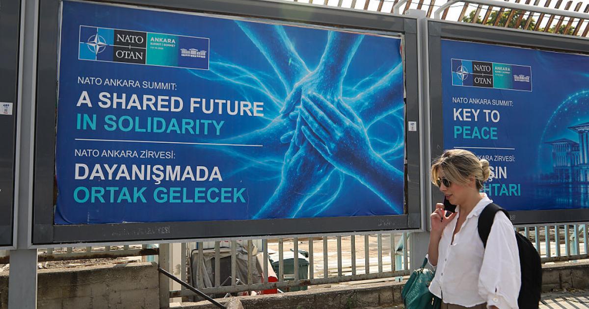 Una mujer camina ante un cartel que anuncia la Cumbre de la OTAN en Ankara, la capital de Turquía, el 5 de julio de 2026.