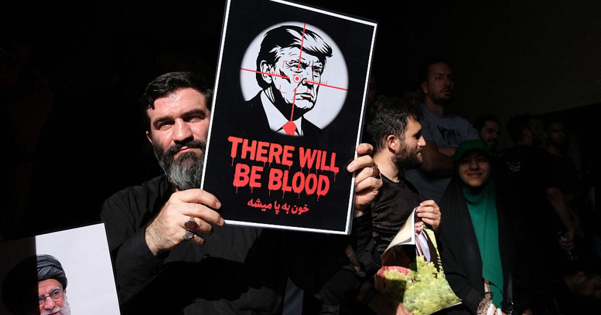 "Habrá sangre", se lee en la pancarta de un iraní, con Donald Trump en la diana, durante el funeral del líder supremo Ali Jamenei, el 5 de julio de 2026, en Teherán.
