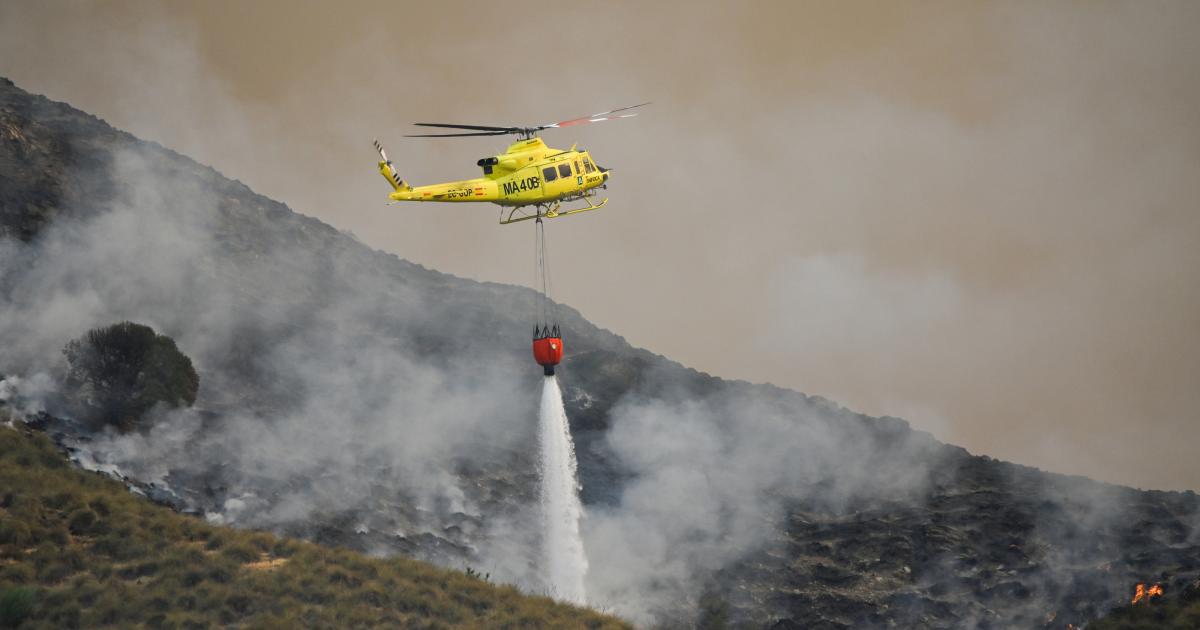 Un helicóptero del servicio de extinción de incendios arroja agua sobre uno de los focos del incendio forestal declarado en Los Gallardos, Almería.