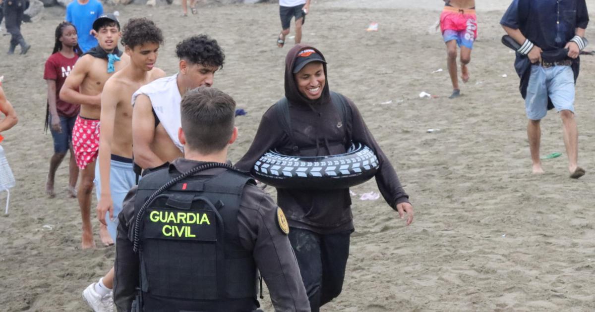 Un grupo de inmigrantes en la playa junto al paso fronterizo del Tarajal en Ceuta este viernes