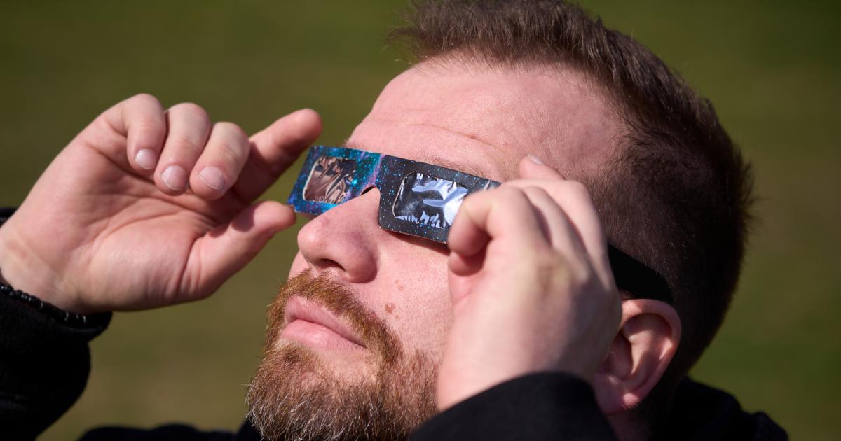 Un hombre viendo un eclipse solar con unas gafas homologadas