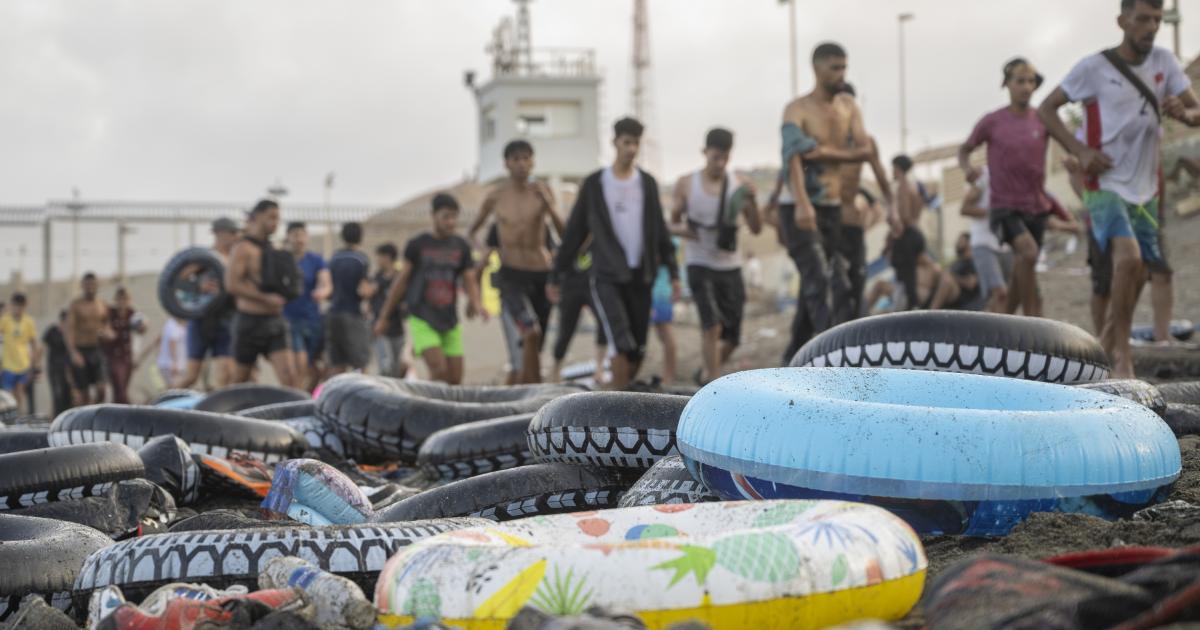 Migrantes que han cruzado a nado la frontera de Ceuta desde Marruecos, en la playa de El Tarajal.