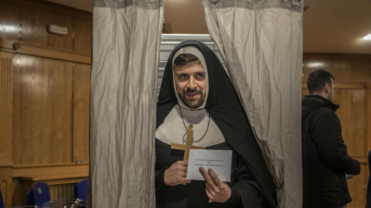 Que el 18F coincida con el carnaval se nota sobre todo en Ourense, que celebra esta fiesta por todo lo alto. En la imagen, una persona disfrazada vota en un colegio electoral en Xinzo de Limia (Ourense), este domingo.