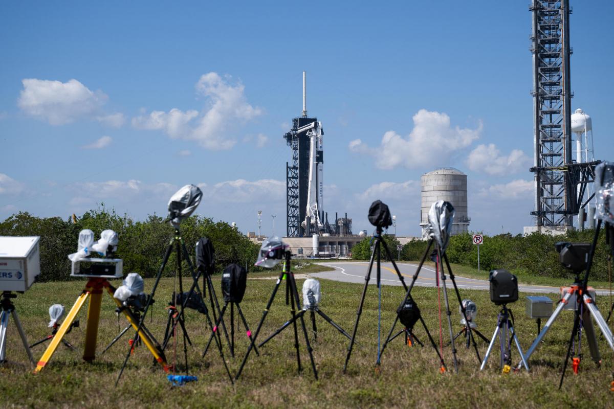 Fotografía cedida por la NASA donde se aprecian una cámaras instaladas por miembros de los medios informativos frente al cohete Falcon 9 de SpaceX con la nave espacial Dragon en la parte superior el sábado 25 de febrero en la plataforma de lanzamiento 39A en el Centro Espacial Kennedy de la NASA en Florida