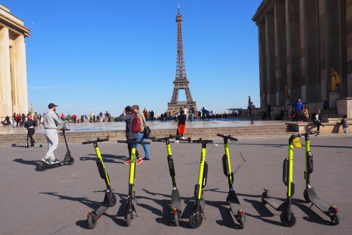 Patinetes eléctricos en París estacionados en la Plaza de Trocadero con la Torre Eiffel al fondo.