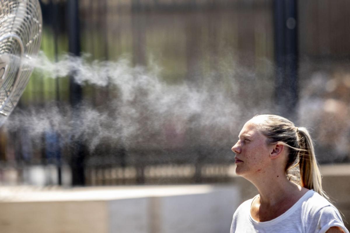 Una joven intenta refrescarse cerca del Coliseo romano en agosto de 2022