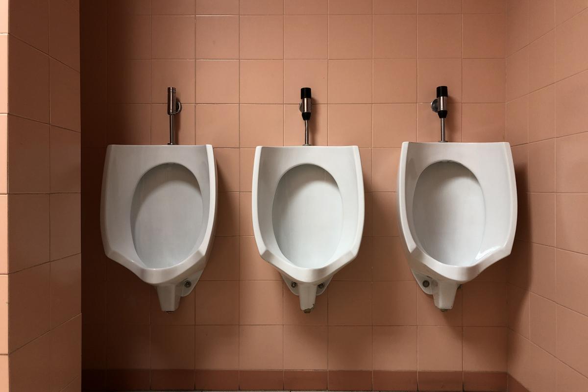 Tres urinarios en un baño público.