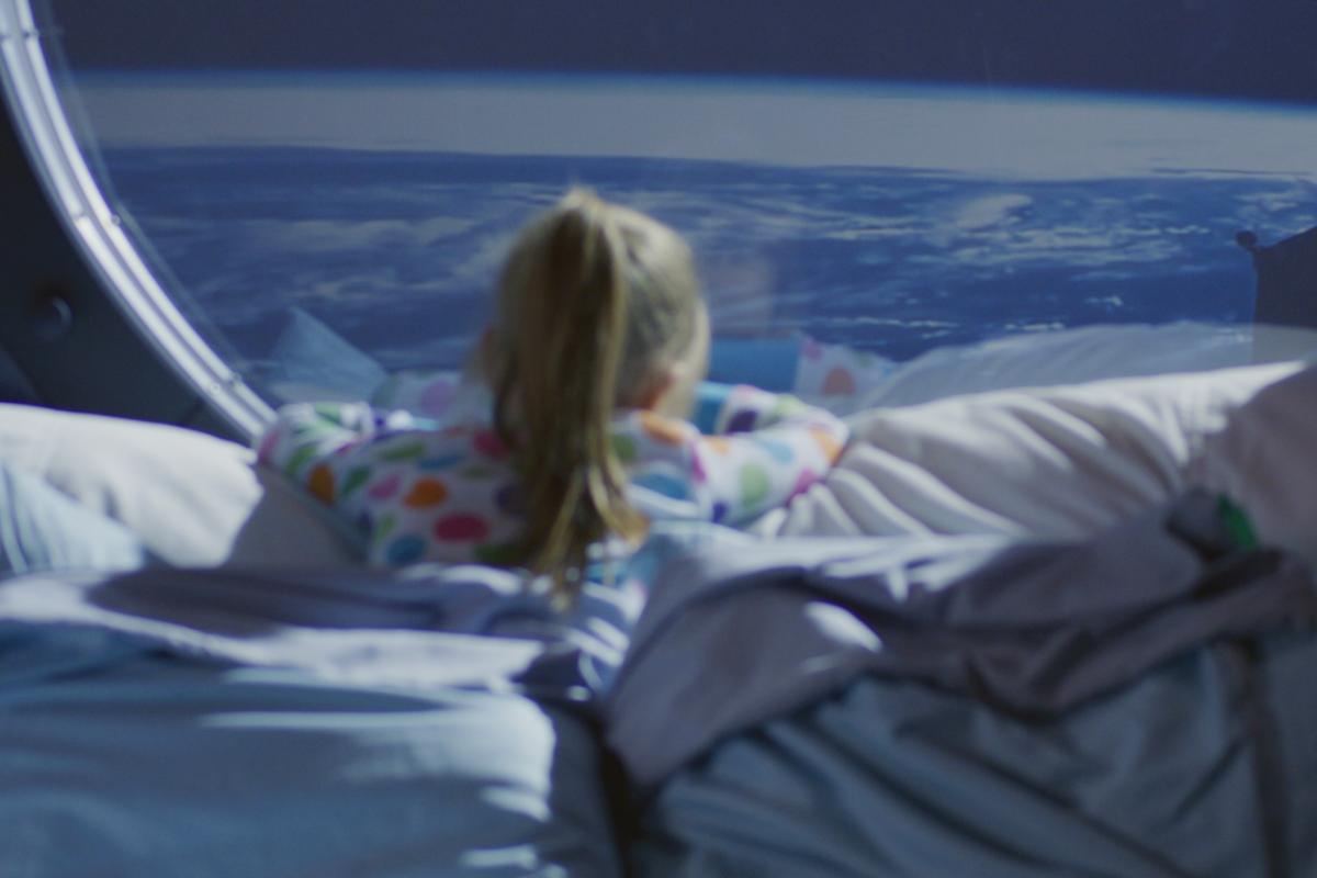 Ilustración de una niña mirando por la ventana de una nave espacial.
