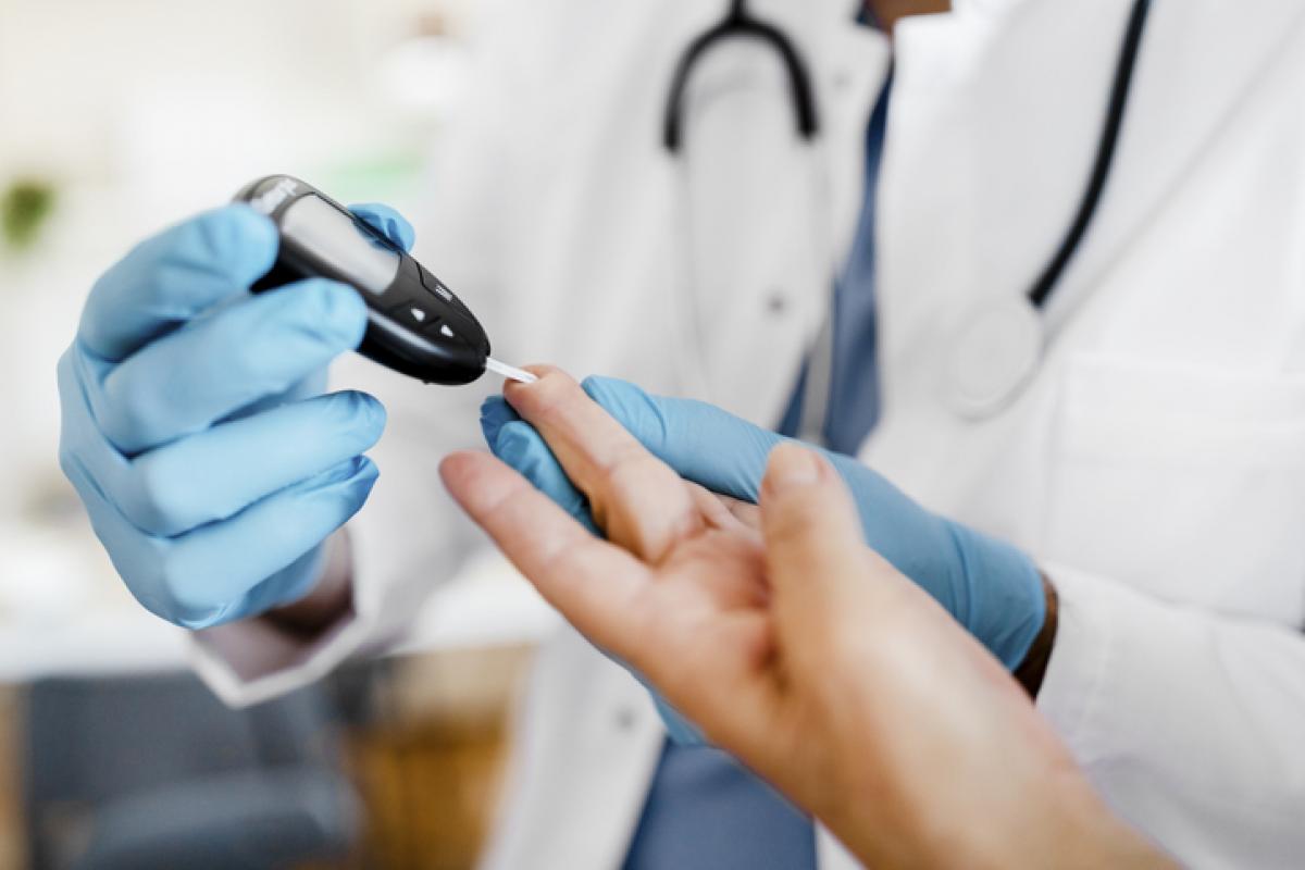 Un sanitario mide la cantidad de azúcar en sangre a un paciente.