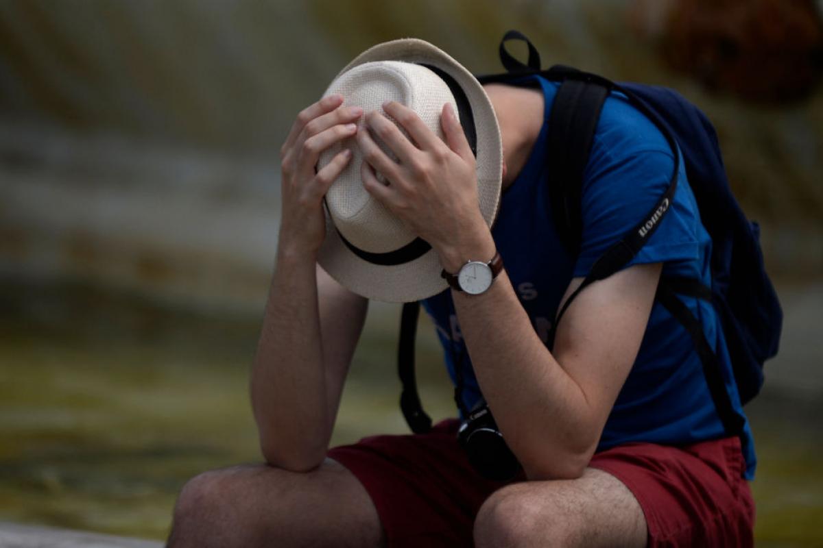 Un hombre se protege como puede en un día de calor fuerte en Sevilla
