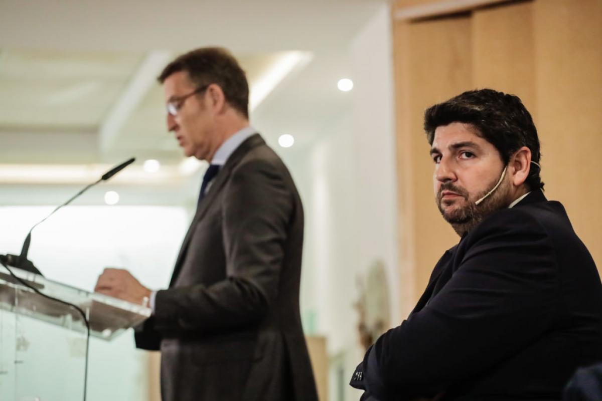 López Miras, mirando durante un discurso de Núñez Feijóo