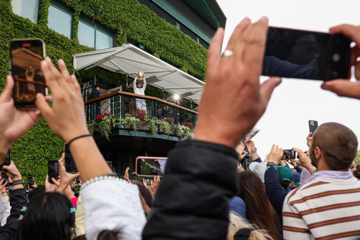 Alcaraz posa con su trofeo en el balcón de la pista central de Wimbledon