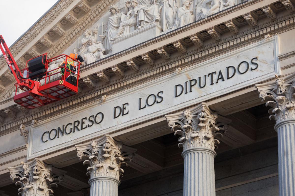 Un operario trabaja en la fachada del Congreso de los Diputados.