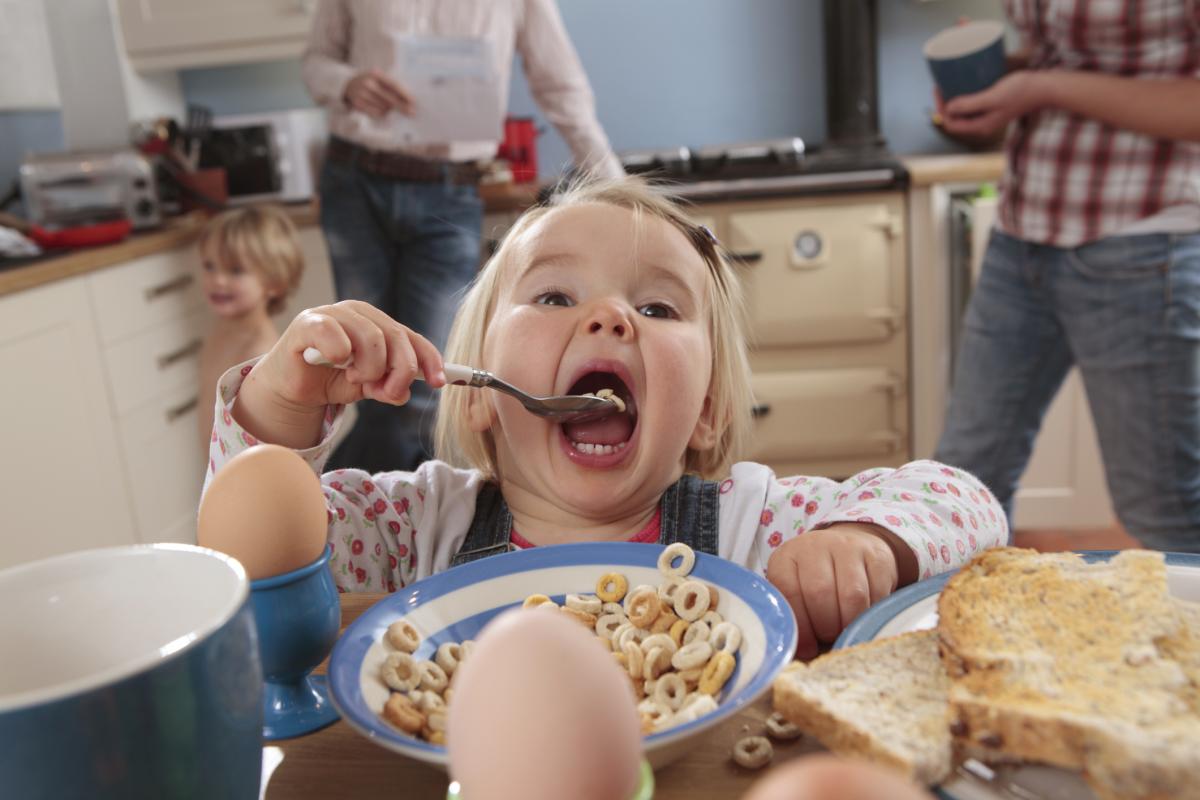 Una niña desayunando.