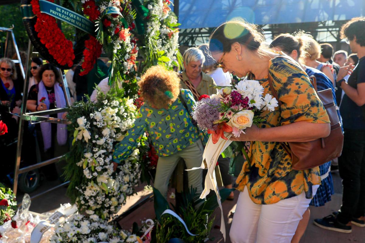 Familiares y amigos de Ramón Lobo recogen flores antes del recorrido de despedida por el cementerio de la Almudena