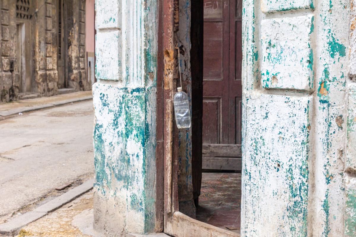 Imagen de archivo de una botella de agua ante la puerta de una vivienda.