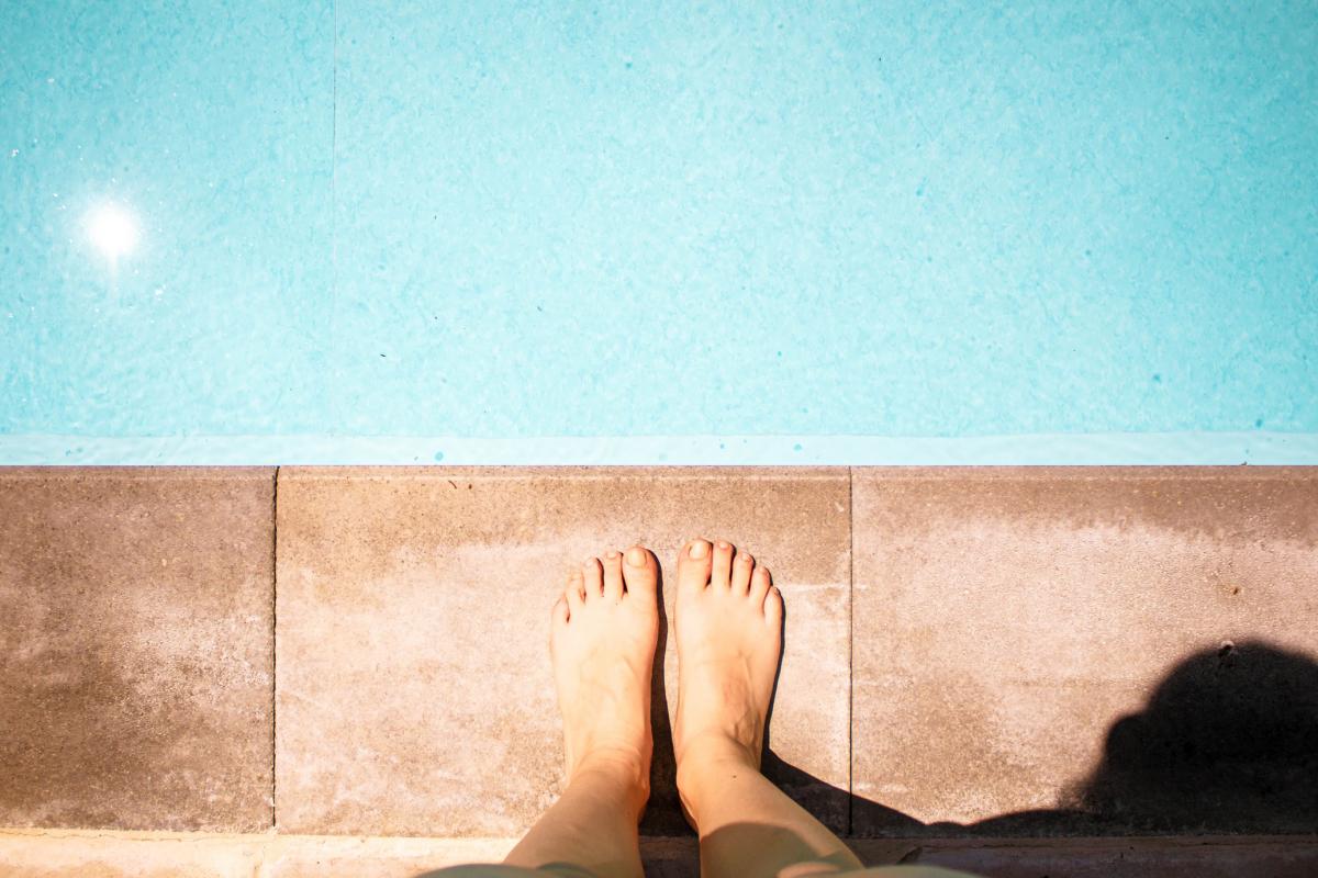 Imagen de archivo de una persona ante una piscina.