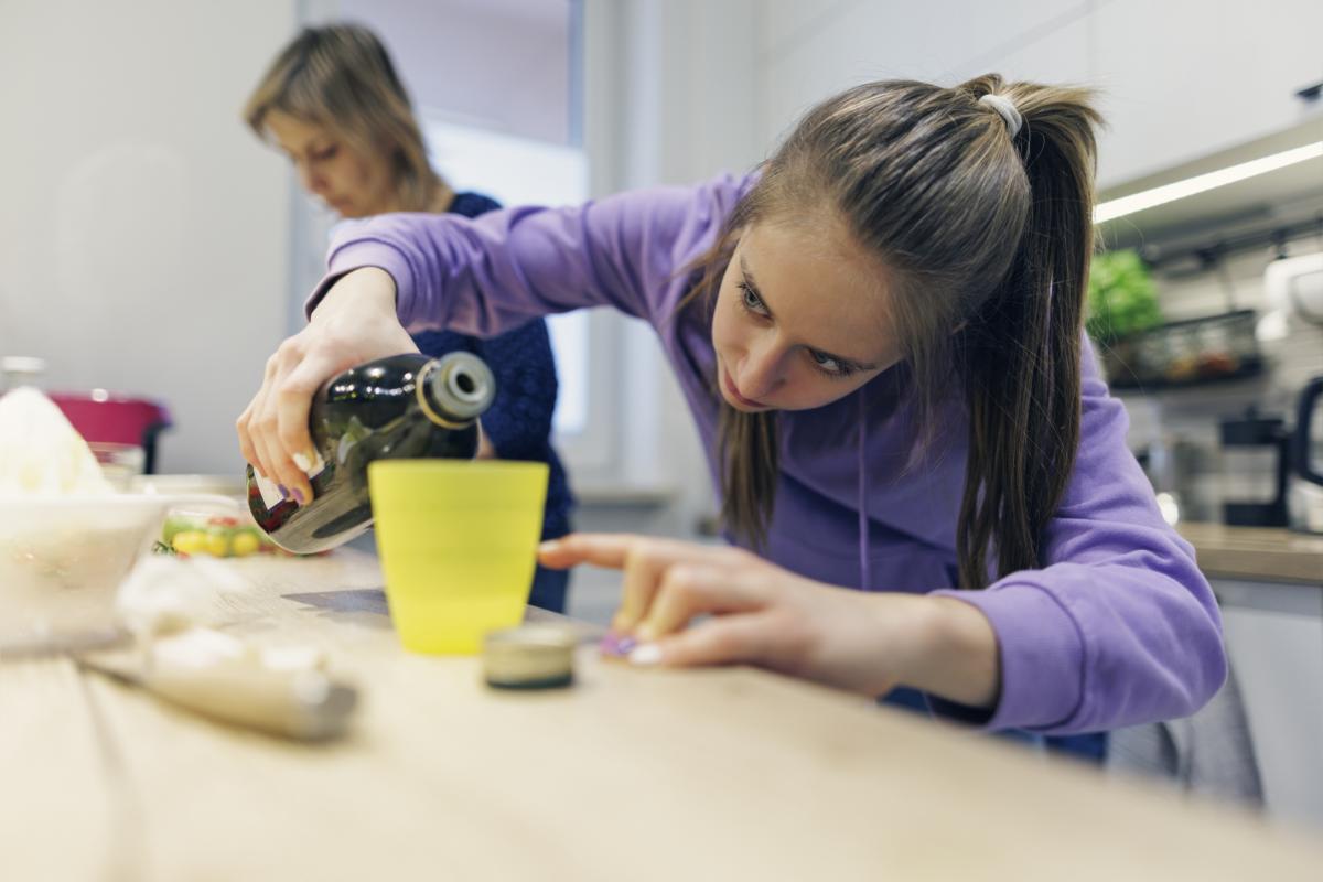 Imagen de archivo de una madre y su hija cocinando con aceite de oliva.
