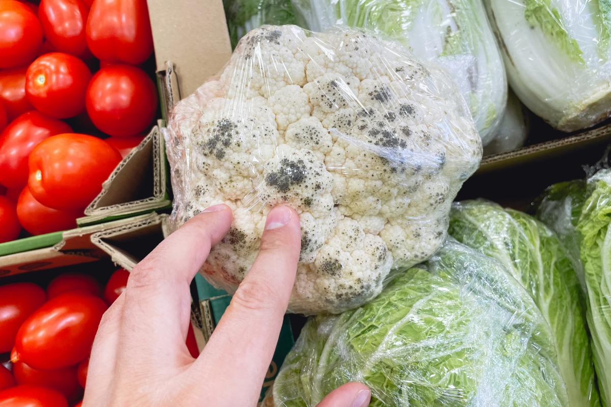 Una coliflor con manchas en un supermercado.