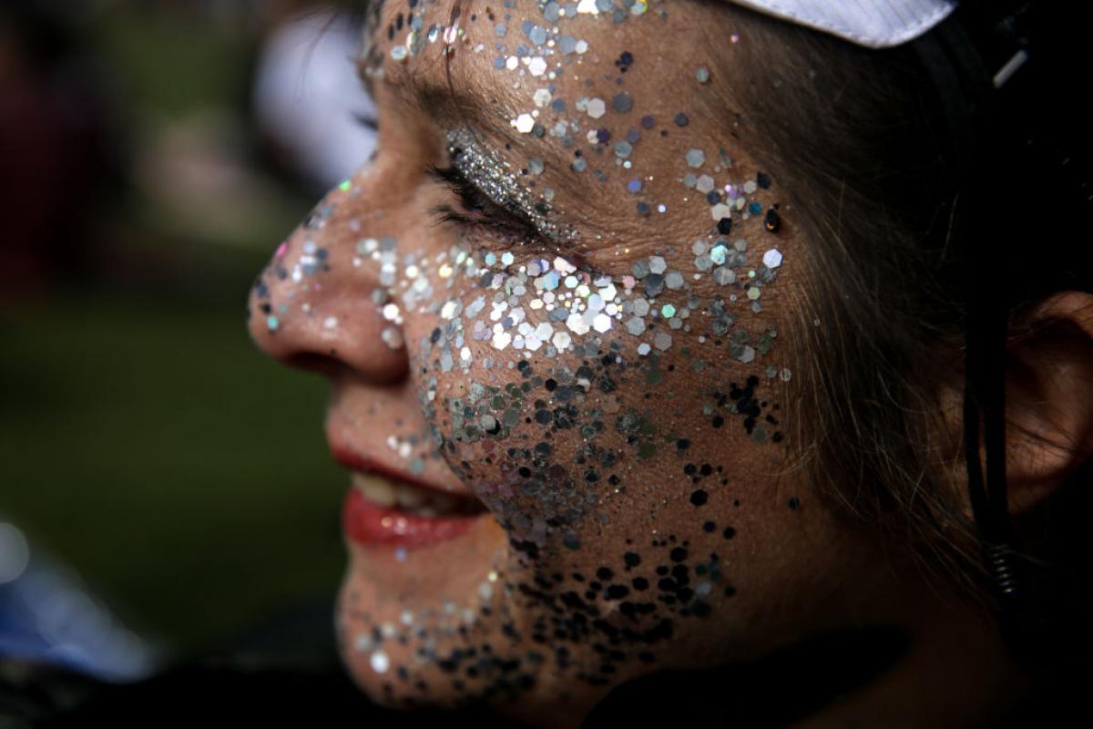 Una mujer, con la cara llena de purpurina.