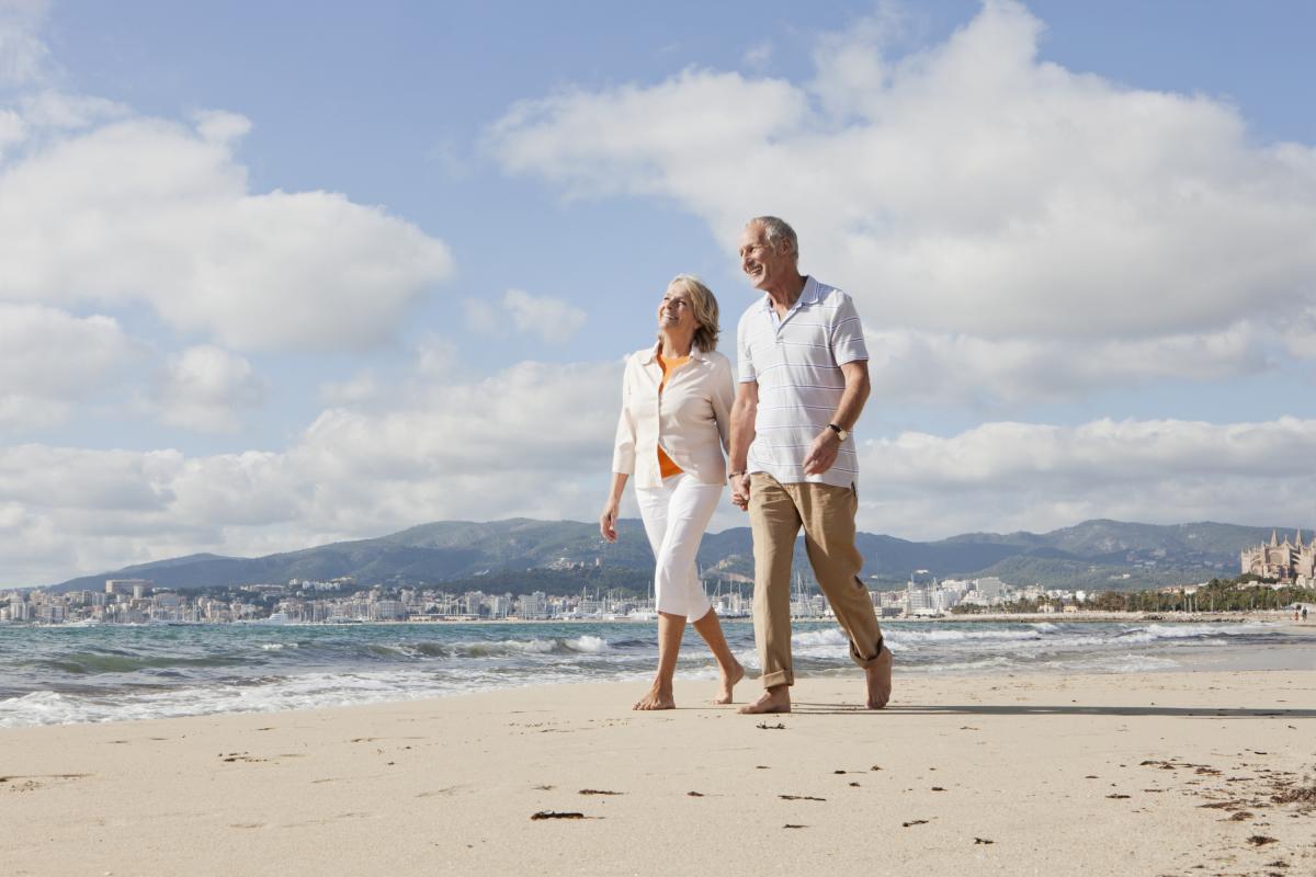 Una pareja de jubilados paseando por una playa de Mallorca