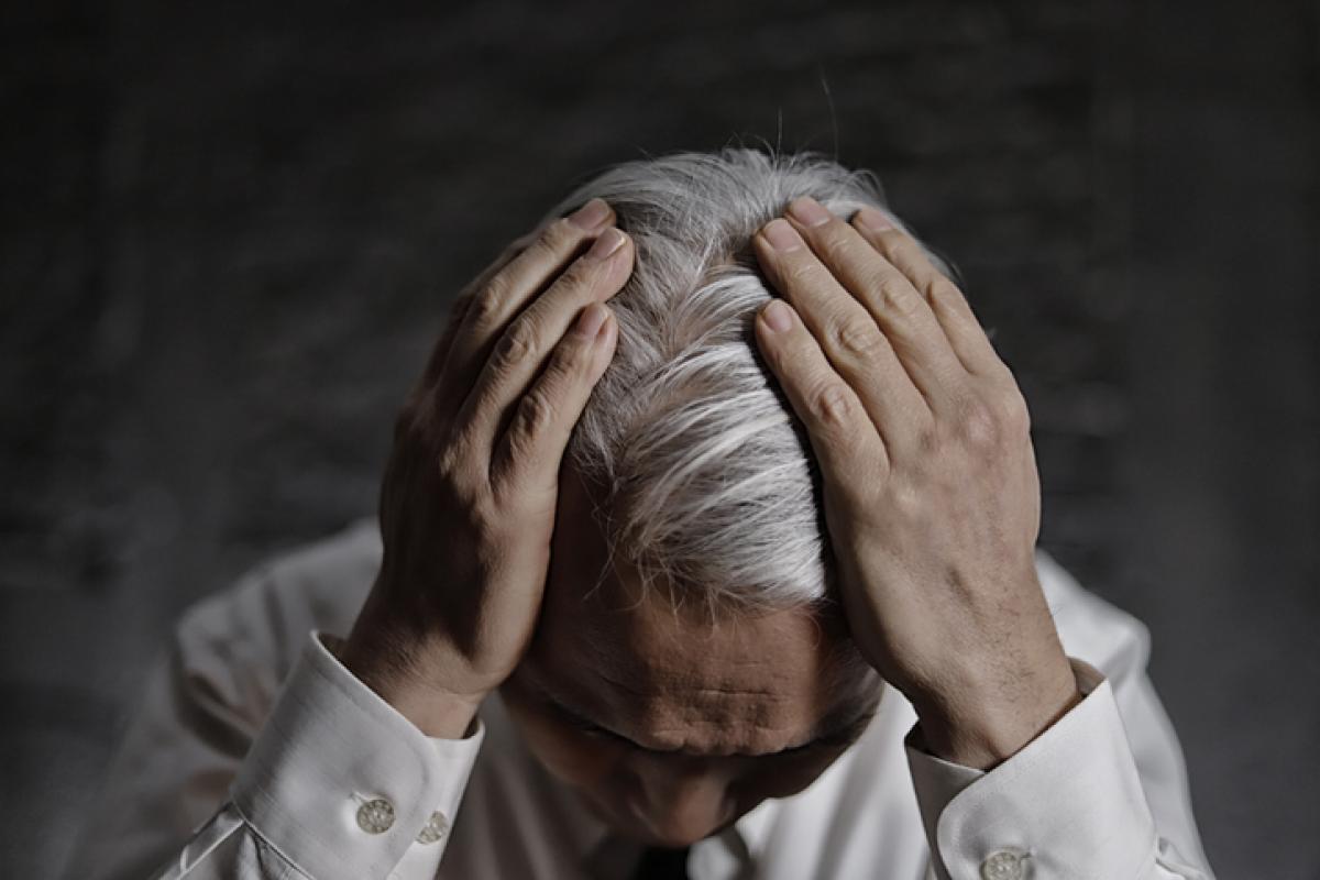 Una persona se toca la cabeza, cuyo cabello se encuentra plagada de canas.
