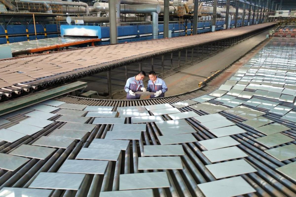 Operarios de una fábrica de cerámica china revisan la producción de azulejos y baldosas.