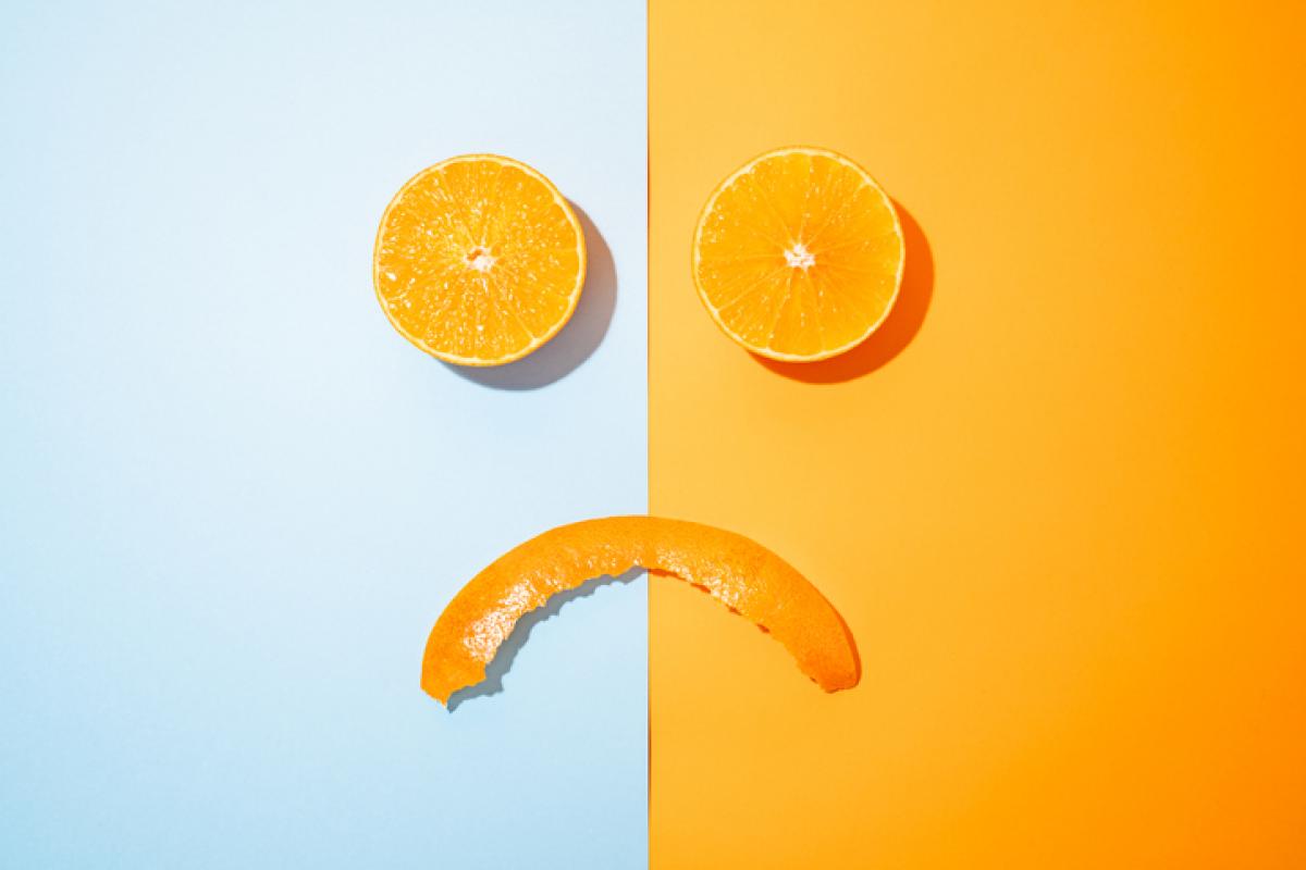Imagen de archivo de gajos de naranja dibujando un rostro triste.