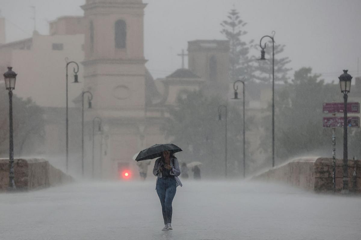 Una persona pasea bajo una tromba en Valencia
