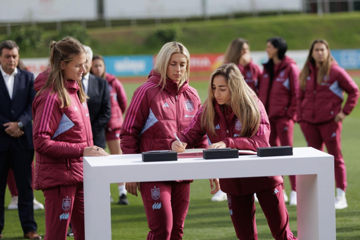 Alexia Putellas, Irene Paredes y Olga Carmona (firmando en ese instante) sellan el acuerdo con la RFEF y el CSD