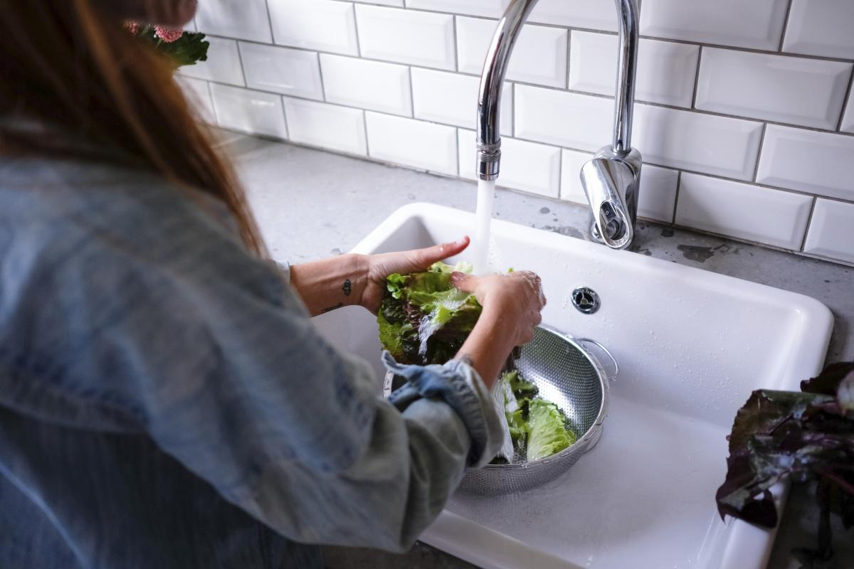 Foto de archivo de una mujer lavando la lechuga.
