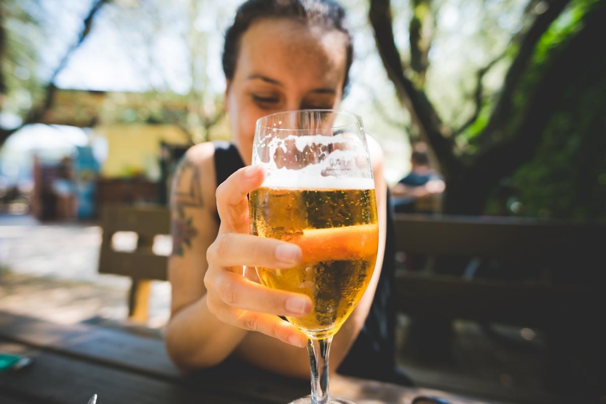 Una mujer consume una cerveza en un bar.