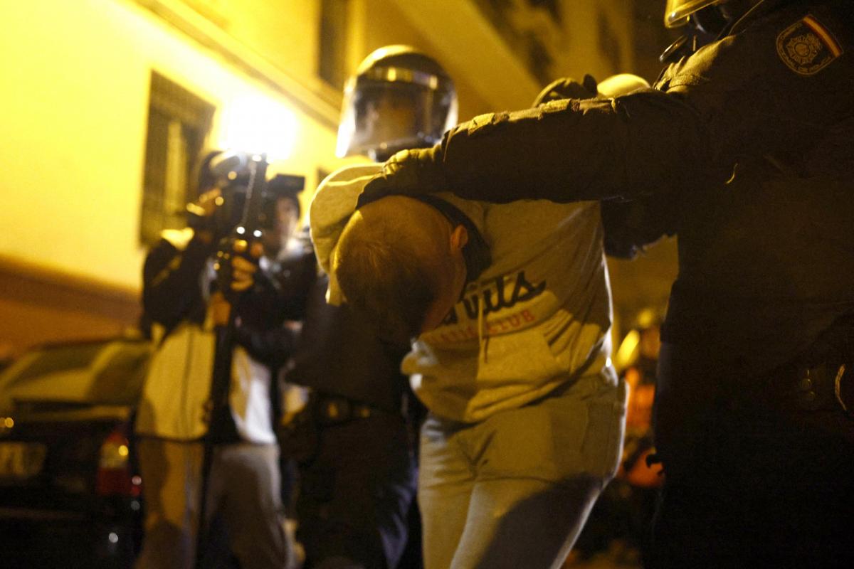 Dos policías detienen a un hombre en las protestas contra la amnistía en Ferraz.