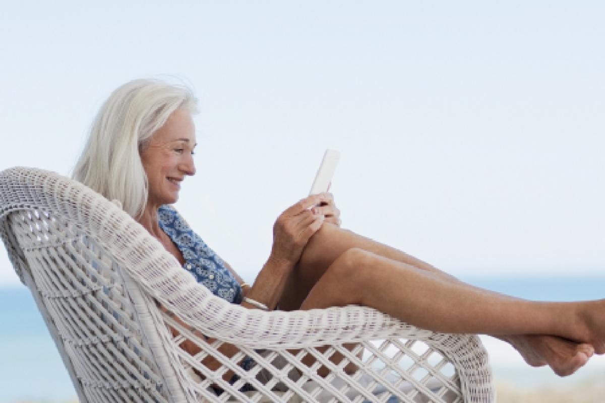 Una mujer leyendo a los pies de la playa