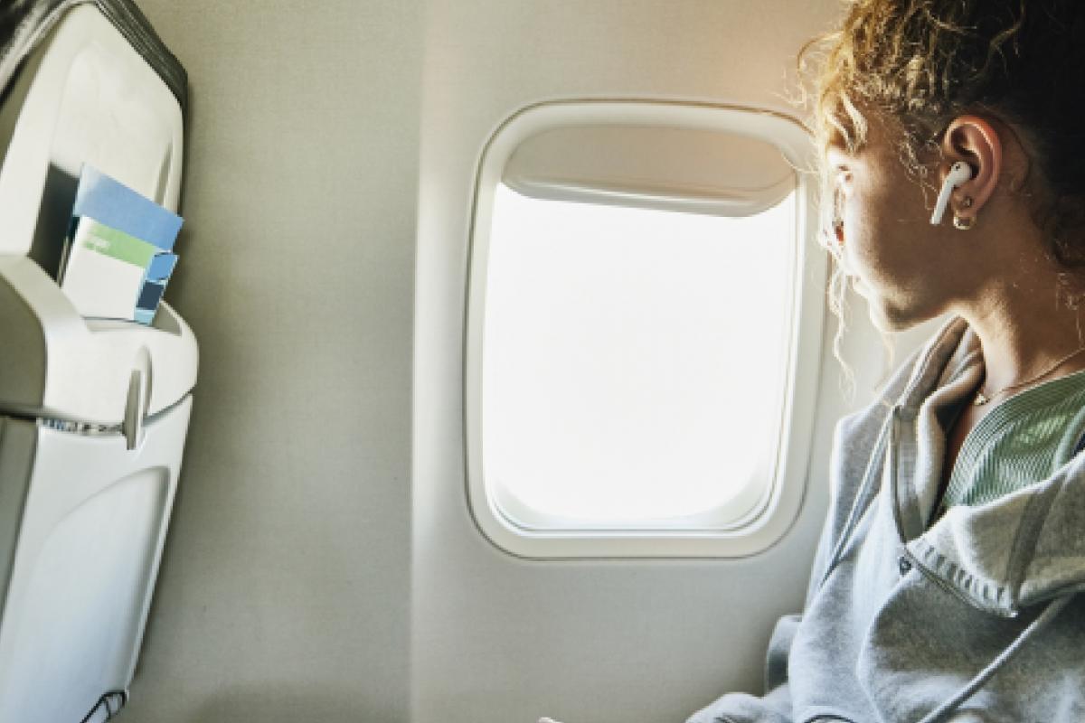 Mujer mirando por la ventanilla en el avión
