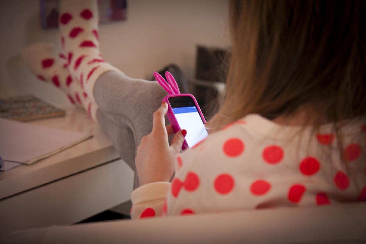 Imagen de archivo de una niña consultando su móvil.