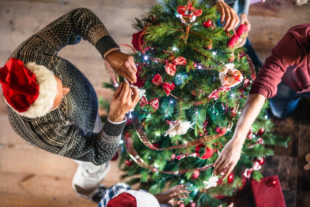 Una persona mayor decorando el árbol de navidad, en una imagen de archivo.