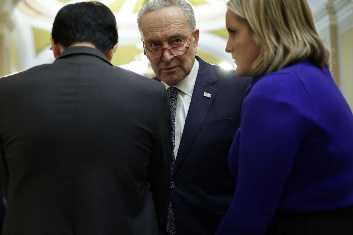 El líder demócrata en el Senado, Chuck Schumer (centro), conversa con varios senadores en los pasillos.