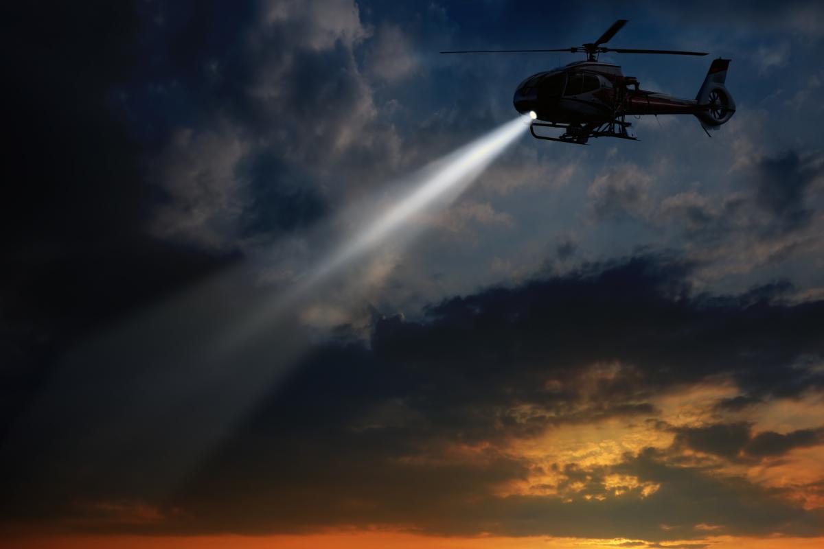 Un helicóptero sobrevuela al atardecer.