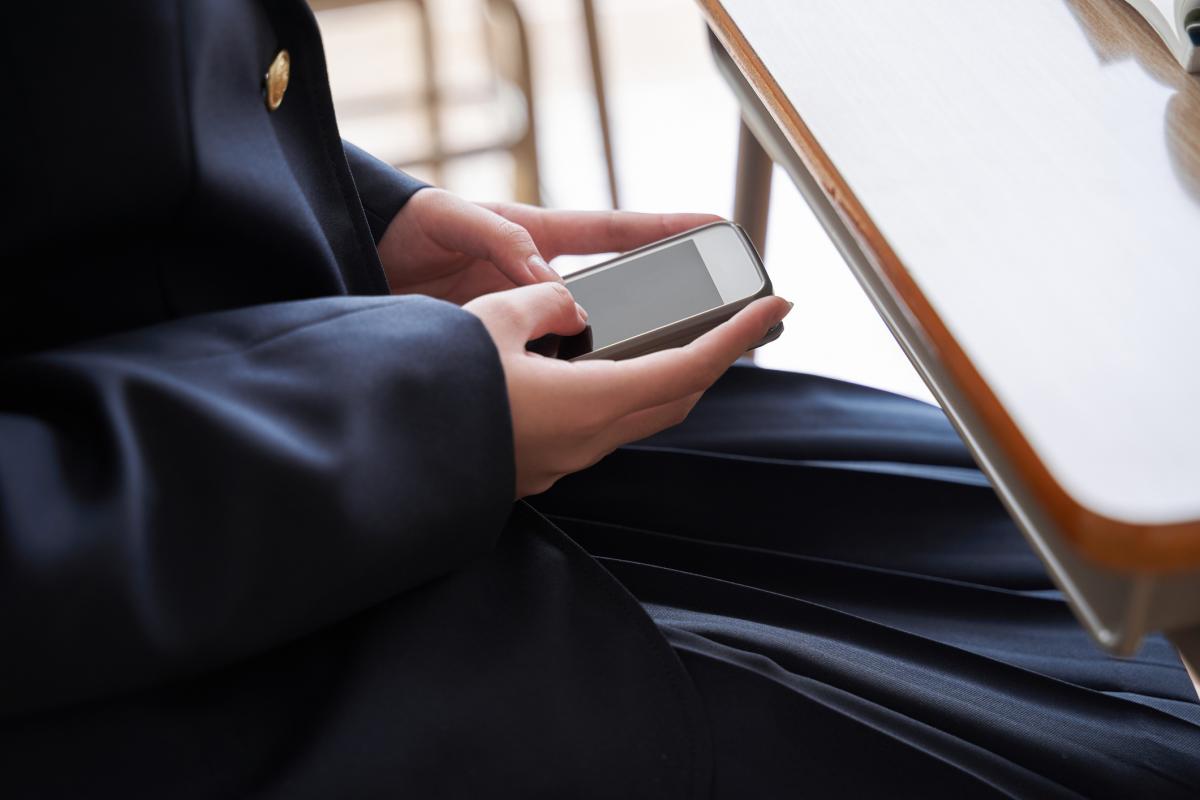 Una estudiante con el teléfono móvil.
