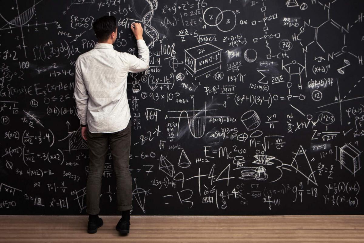 Persona inteligente escribiendo una formula en la pizarra