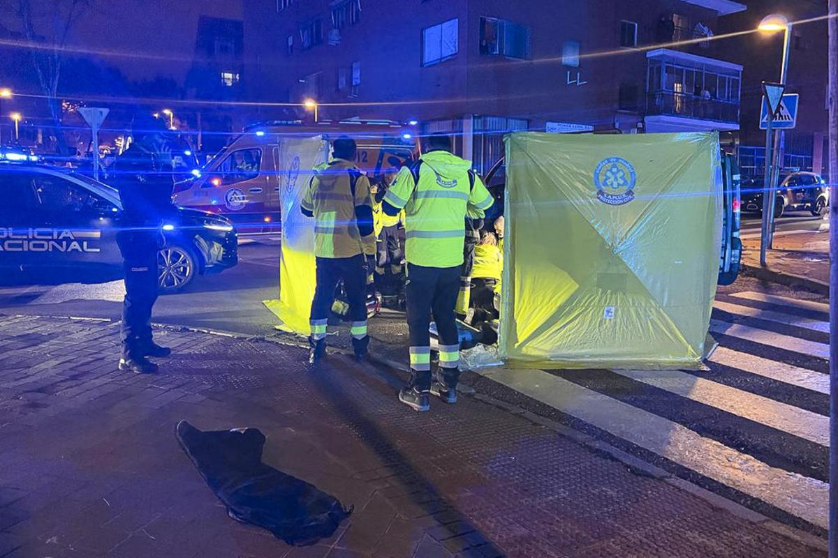 Miembros de Emergencias Madrid atienden a la mujer asesinada en el distrito de Puente Vallecas, Madrid.
